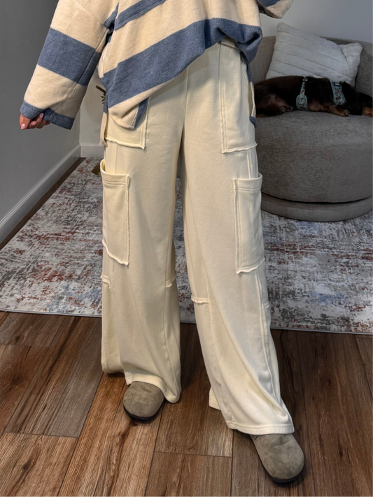 Person wearing beige cargo pants and a striped sweater in a living room.