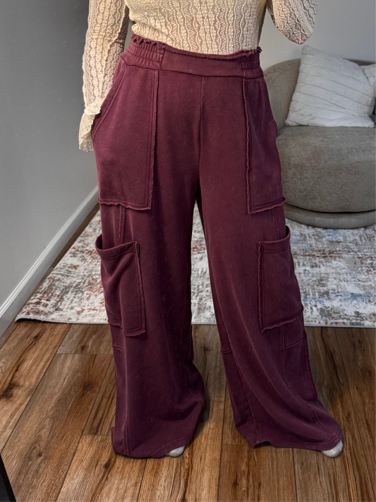Person wearing maroon cargo pants in a living room setting