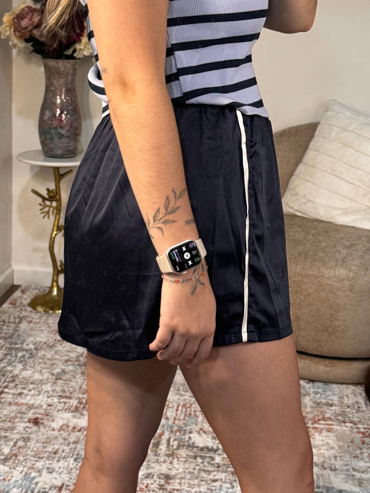 Person wearing a striped shirt and black shorts in a living room setting.