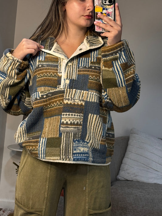 Person wearing a patterned coat sitting on a couch.
