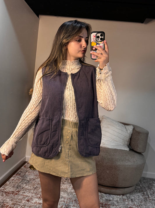 Person taking a mirror selfie in a room with a sofa and cushions.