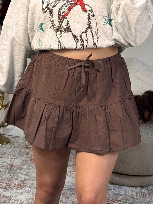 Brown tiered skirt worn by a person with a neutral background