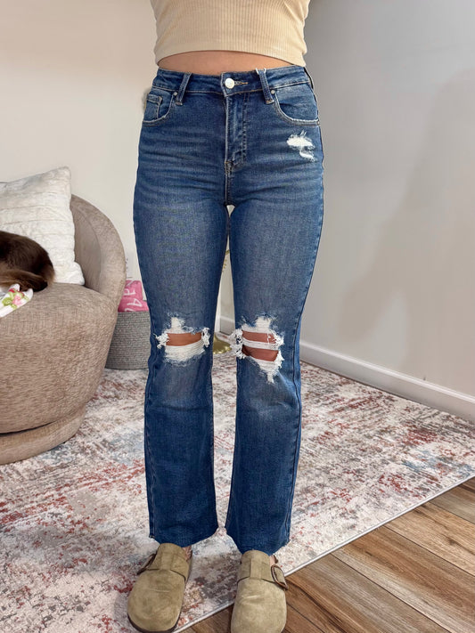 High rise straight leg jeans with knee distressing and raw hem. Stretch denim