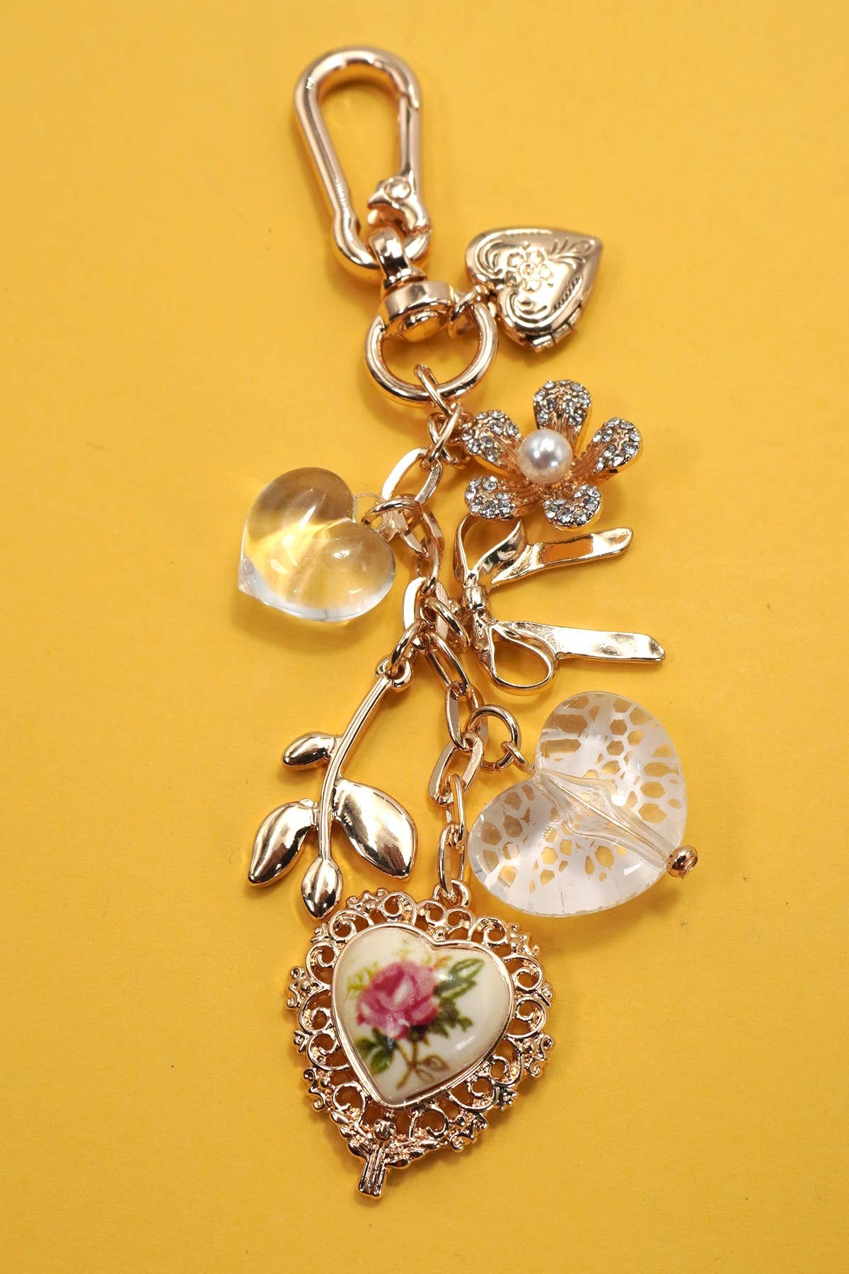 Decorative bag charm with heart-shaped charms on a yellow background
