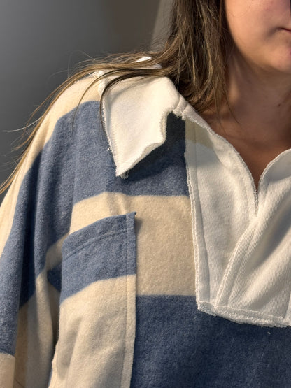 Close-up of a person wearing a striped shirt with a neutral background