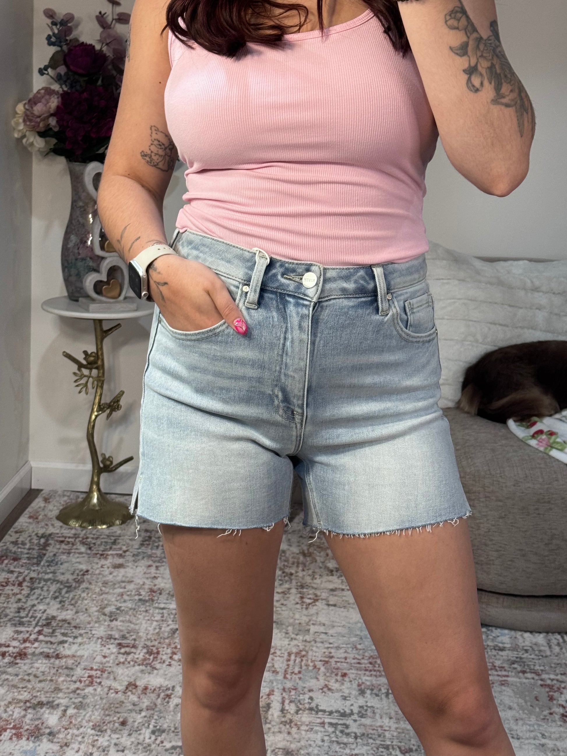 High rise denim shorts with raw hem and side slits. Light wash, stretchy,