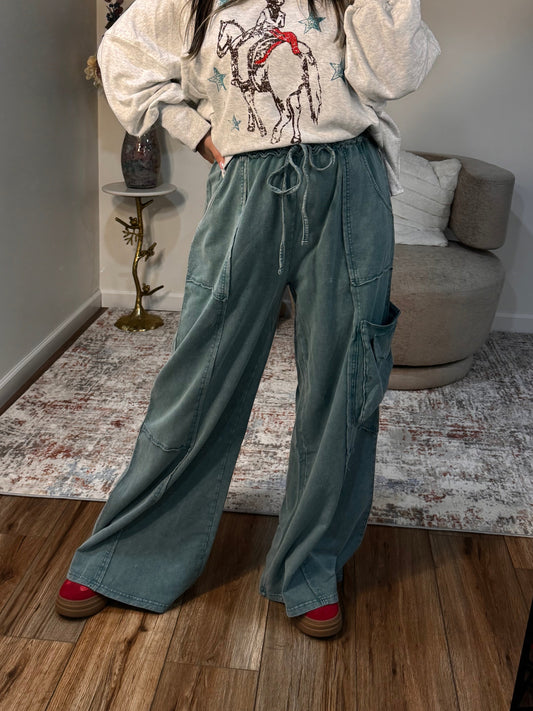 Person taking a mirror selfie wearing a graphic hoodie and jeans in a room.