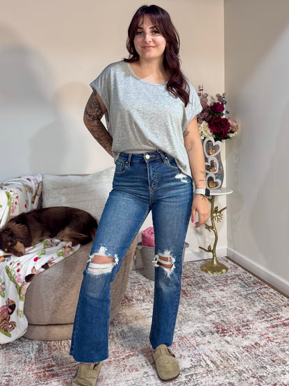 High rise straight leg jeans with knee distressing and raw hem. Stretch denim