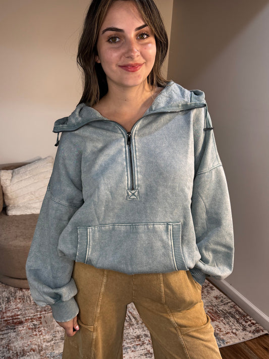 Person wearing a light blue denim jacket and brown pants indoors.