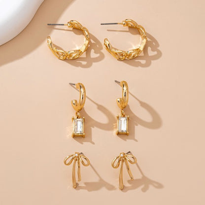 bow earring set, gold huggie earrings with charms, baguette crystal earrings, cute dainty earring sets, and trendy ear stack sets