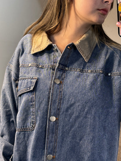 Close-up of a person wearing a blue denim shirt with a neutral background