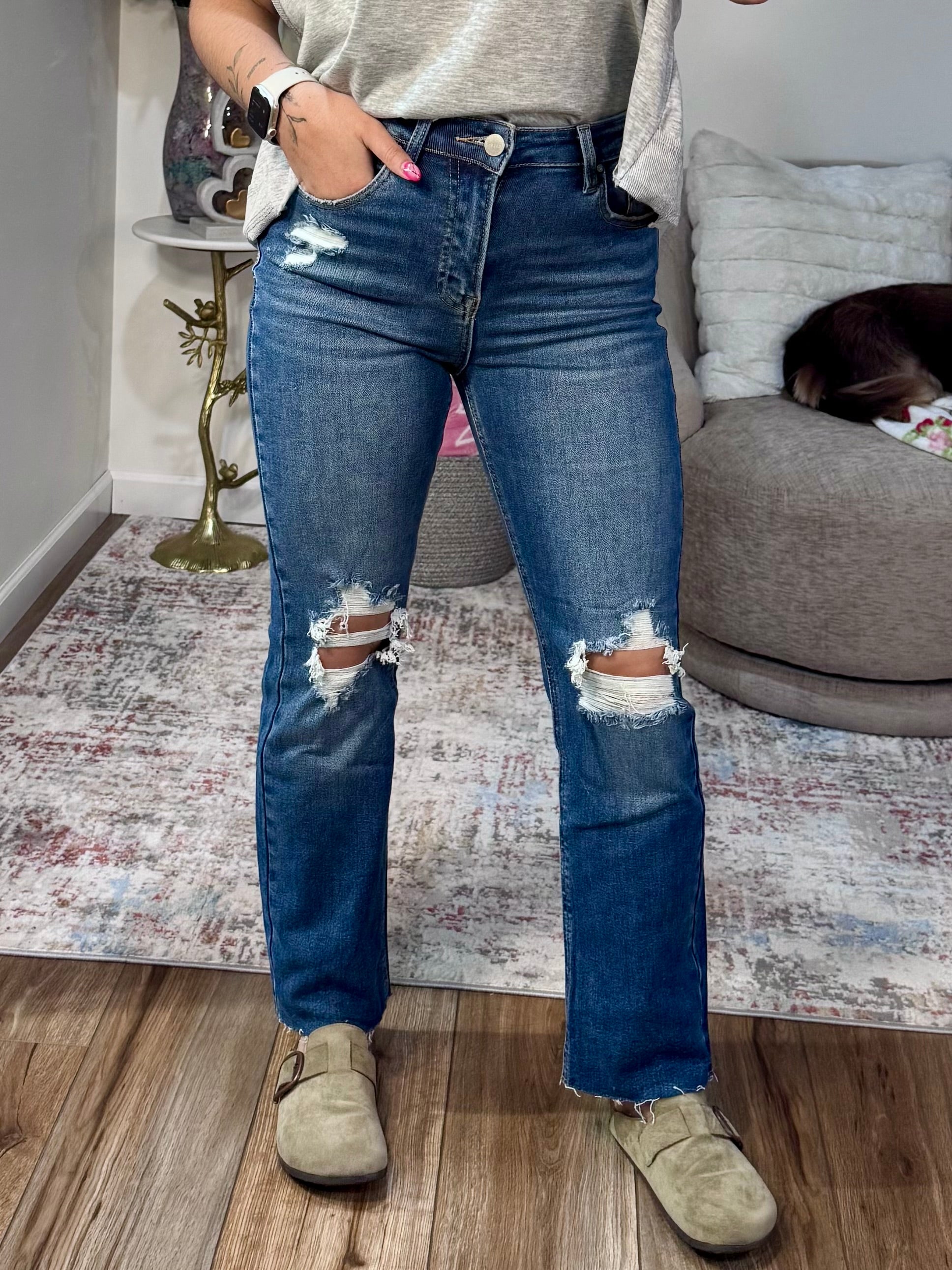 High rise straight leg jeans with knee distressing and raw hem. Stretch denim