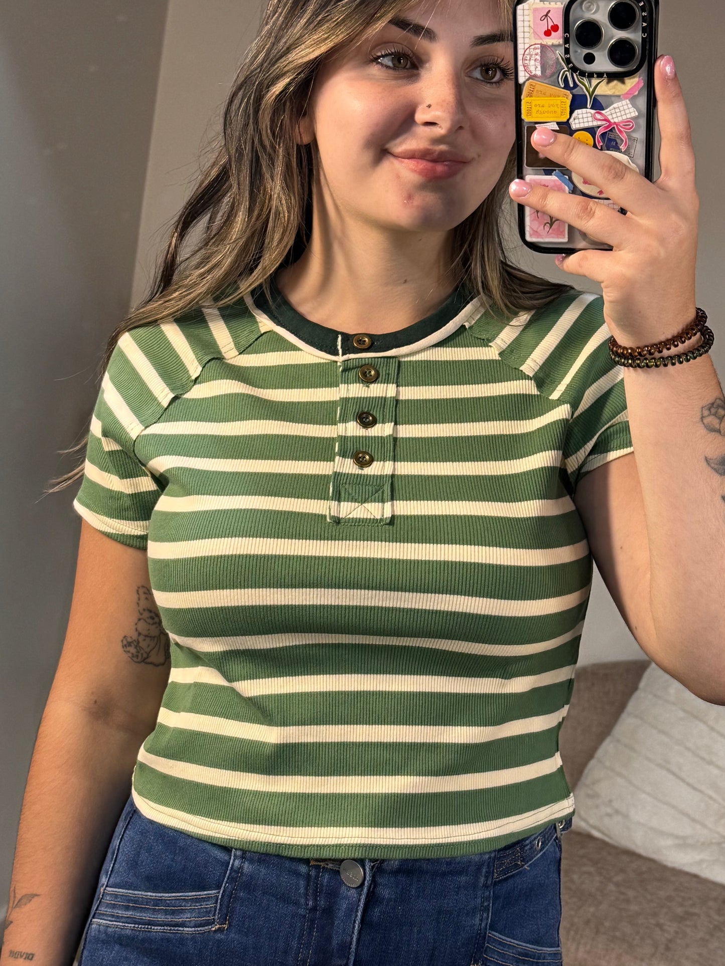 Person wearing a green and white striped shirt taking a selfie.