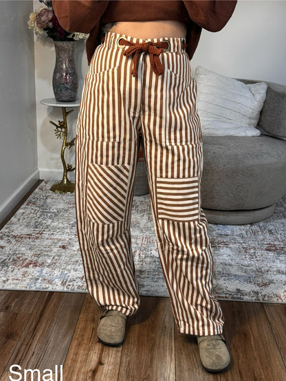 Person wearing brown and beige striped pants in a living room setting.