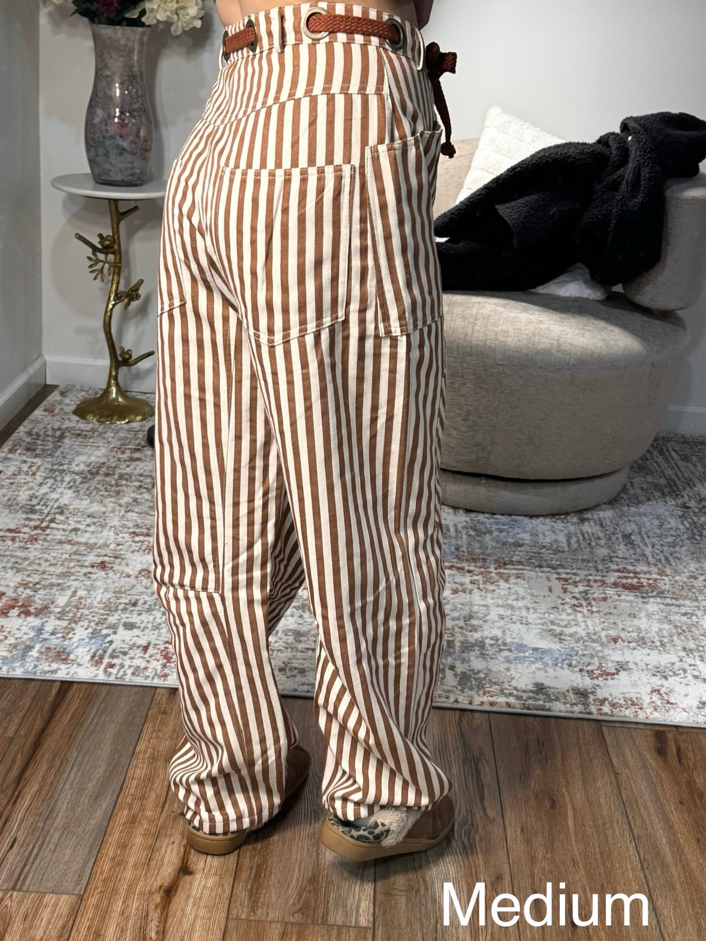 Person wearing brown and beige striped pants in a living room setting.