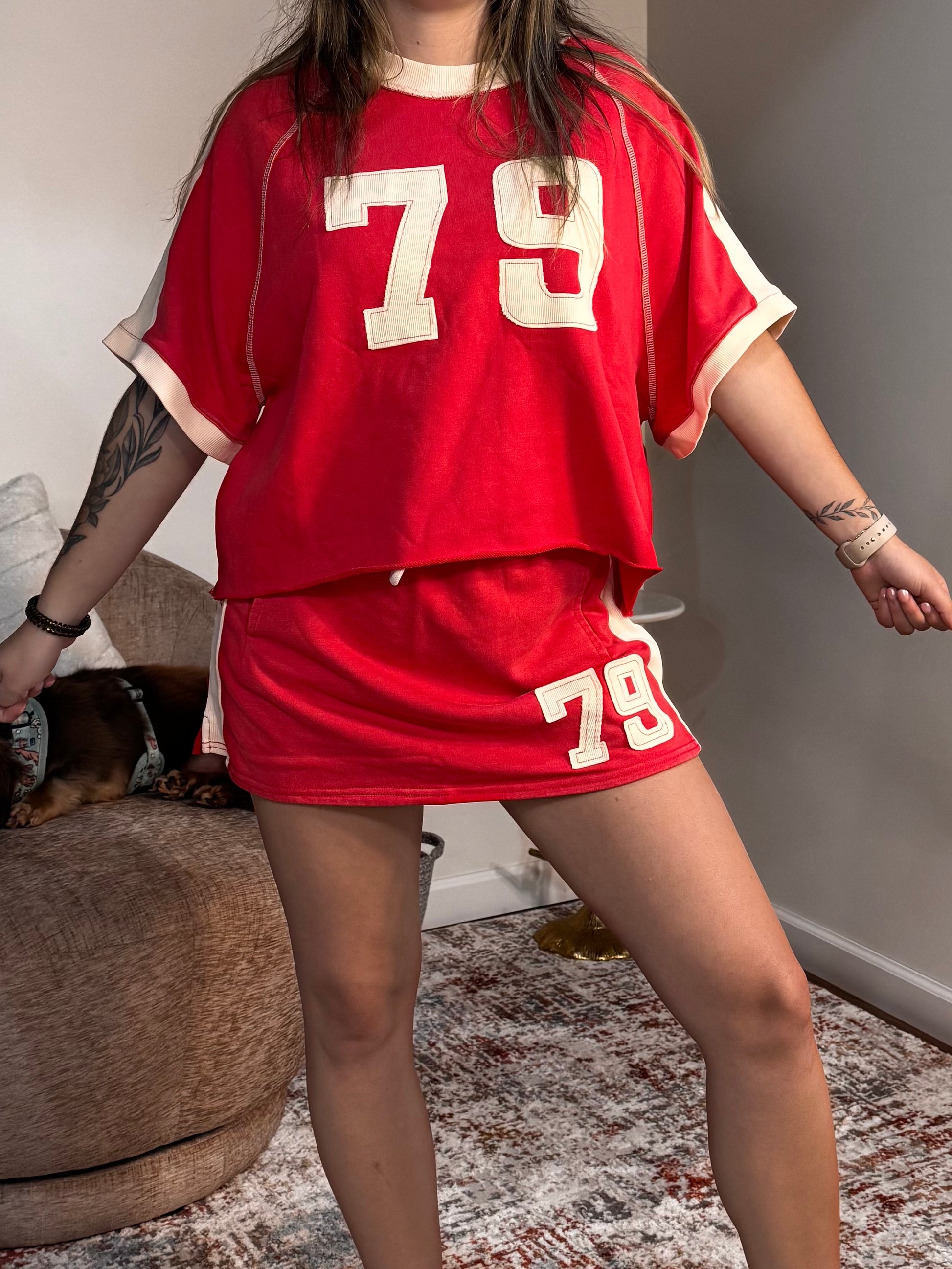 Person wearing a red outfit with the number 79 in a casual indoor setting