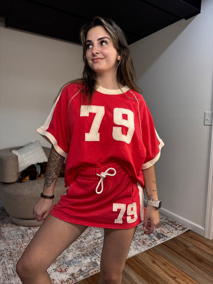 Woman wearing a red outfit with the number 79 in a casual indoor setting
